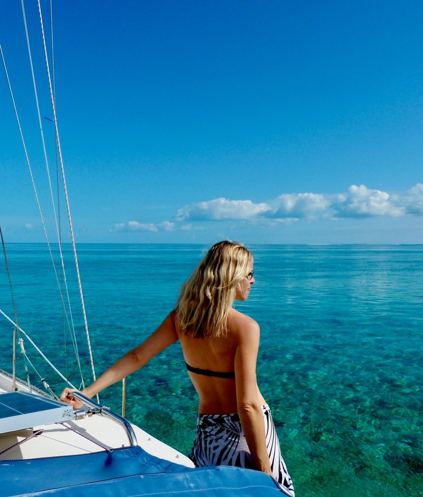 Julie aboard her sailboat looking out across turquoise Bahamian waters